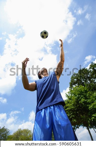 Man looking up at soccer ball