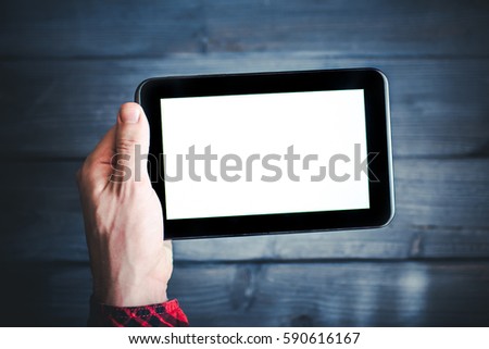 Man in red shirt holding blank screen empty copy space tablet over blue wooden table.