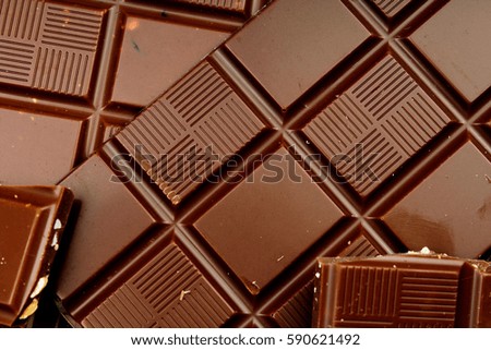 Chocolate bars as background. Milk and dark shiny chocolate texture. Stack chocolates pattern. Stunning beautiful cacao brown dessert sweets. 
