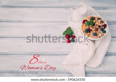 the text 8 March, observance of the womens day on a table set for breakfast, with a bowl with cereals  and rose