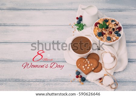 the text 8 March, observance of the womens day on a table set for breakfast, with a bowl with cereals  and rose