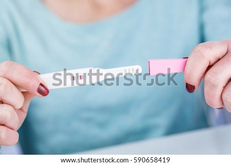 woman holding a Pregnancy Test pregnancy test positive result in her hands