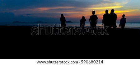 Silhouette group of people walking on the beach after sunset time, Hello summer concept