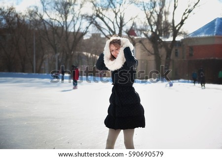 Beautiful girl at the rink in a black jackett. Amazing blonde skates winter day. Saratov, Russia