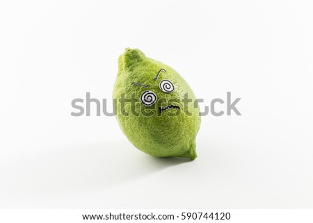 A fresh green lemon with sour looking cartoon style face on white background