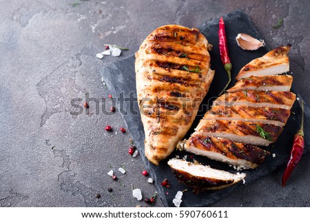 whole and sliced chicken breast with spices on a stone board, top view copy space Royalty-Free Stock Photo #590760611