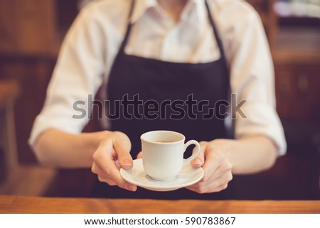 Close up of professional barista. Woman making coffee and presenting it