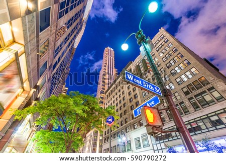 Manhattan at night. Street signs with tall skyscrapers on backhround.