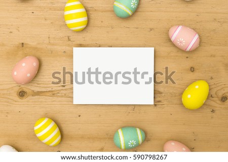 Easter holiday background. Pastel coloured decorated easter eggs with a blank white label on a wooden background