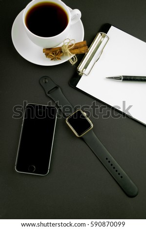 clock, phone, notebook, pen, on a black background