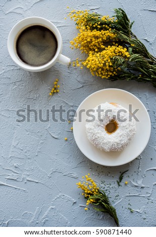 Cup of coffe and a donut on concrete background