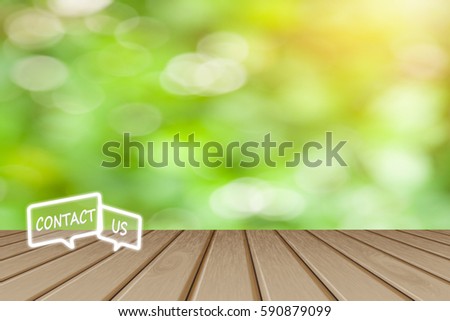 Contact us Button concept, Wooden board empty top table  icon with blurred  tree with bokeh  background - can be used for display or montage your products and text.