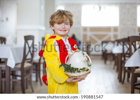 red-haired boy with freckles in carnival costume eats breakfast at home or in a restaurant, a plate of pancakes, a delicious breakfast, child in yellow carnival dress, holiday breakfast, good morning.