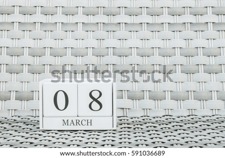 Closeup surface white wooden calendar with black 8 March word on blurred weave wood chair textured background with copy space , selective focus at the calendar