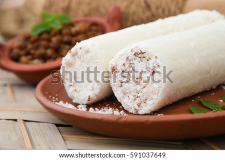 Popular South Indian breakfast puttu / pittu made of steamed rice flour and coconut  in the bamboo mould with spicy Bengal gram curry / utensil, Kerala, India. Bamboo puttu. Sri lankan food