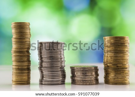 Growing coins stacks with green and blue sparkling bokeh background. Financial growth, saving money, business finance wealth and success concept.