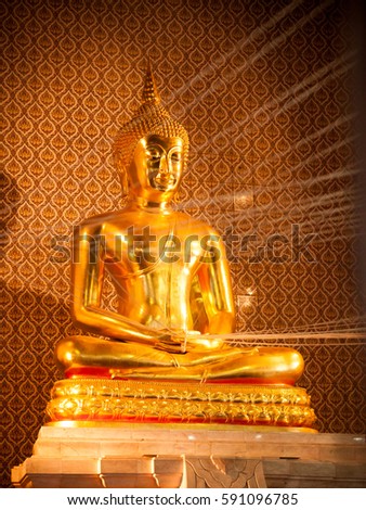 Golden statue of buddha with holy thread in the temple.