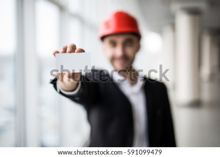 Construction worker holding blank business card in building construction.