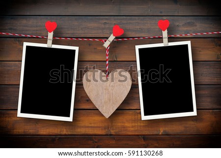 Wooden heart and two empty photo frames on a rustic wooden background as love concept for valentines day