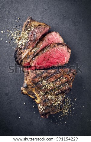 Barbecue dry aged Rib of Beef as close-up on a black slate