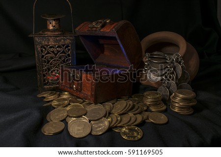 Treasure chest, pile and pillar of coins, and a ceramic bowl filled with jewelry coins in dark environment