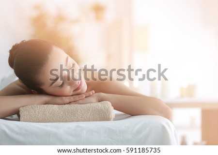 Beautiful young woman in spa salon Royalty-Free Stock Photo #591185735