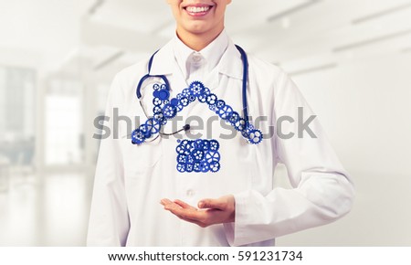 Hand of woman doctor showing house or home gear sign in palm