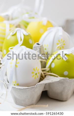 Easter decorative eggs in carton. Yellow,white,green.Background. Selective focus. Copy space.Easter concept. Closeup photo.