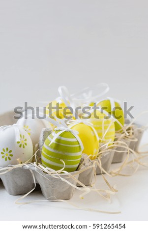 Easter decorative eggs in carton. Yellow,white,green.Background. Selective focus. Copy space.Easter concept. Closeup photo.