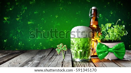 St Patrick's Day - Green Beer In Glass With Bottle And Clovers On Wooden Table
