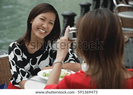 Woman taking a picture of another woman