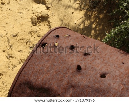 Iron old barrel with bullet holes as war trail in the dessert of Negev, Israel.