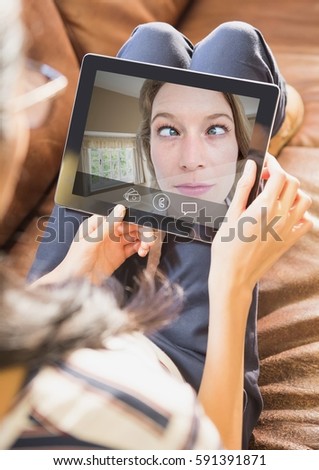 Woman having video call with friend on digital tablet at home
