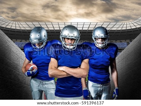 Determined american football players standing against stadium in background