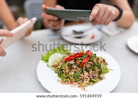 People taking photo on food with mobile phone
