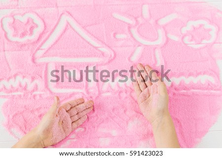 House painted children's hands on the decorative sand. Children's educational creative concept.