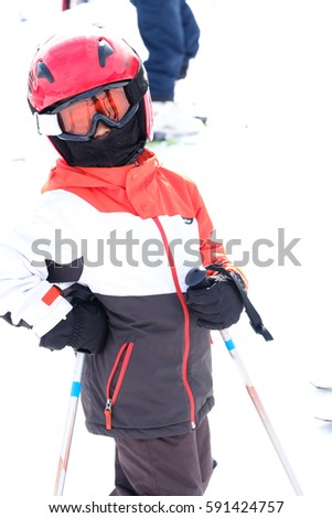 young boy with helmet preparing to take chairlift in alpes mountain station