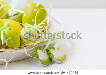 Easter decorative eggs,wooden chicken shaped decoration.Yellow,green,white. Background. Selective focus. Closeup photo. Easter concept.Copy space.