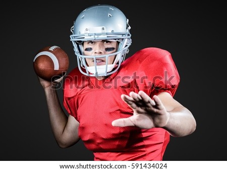 Portrait of athlete playing american football against black background