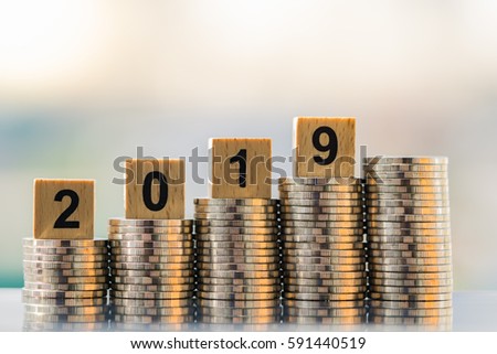 2019 NEW YEAR with stacked coins on wooden block. Business and Financial concept.