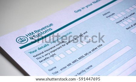 Photo of filling in a HM customs form a personal details for UK self assessment tax and benefits right. Royalty-Free Stock Photo #591447695