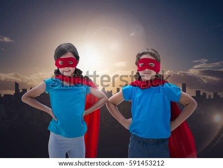 Digital composite image of smiling kids in red cape and mask standing with hand on hip against cityscape