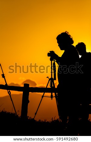 Silhouette of a photographer who was happy to shoot in the morning.