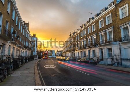 Block of flats at sunset and the light of the cars marking lines during the long exposure at rush hour Royalty-Free Stock Photo #591493334