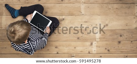 Kid playing with his tablet header image Royalty-Free Stock Photo #591495278