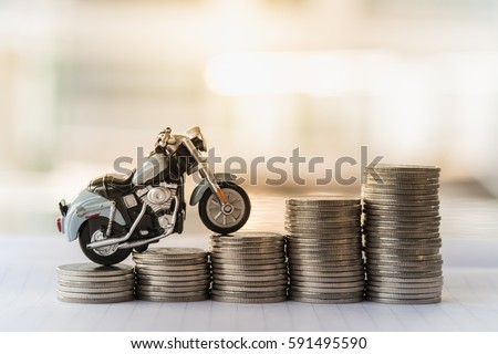 Mini motorcycle model on stack of coins. Saving, Finance, Loan and leasing Concept.