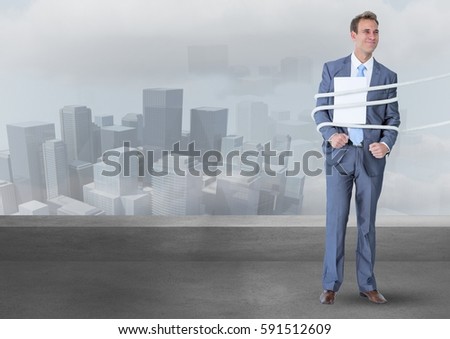 Digital composite image of businessman tied up in rope against cityscape