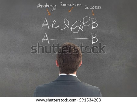 Digitally composite image of businessman looking at business terms on chalkboard
