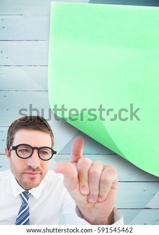 Digital composition of businessman pointing at sticky note on wooden background