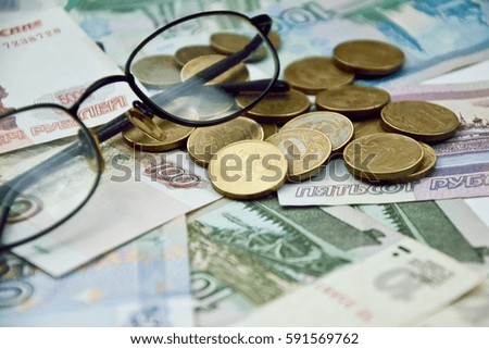 glasses and a few coins on the banknotes. russian money for backgrounds and illustrations